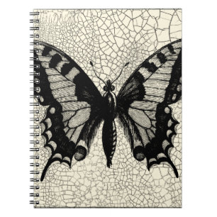 Caderno Espiral Borboleta Preta e Branca sobre fundo rachado