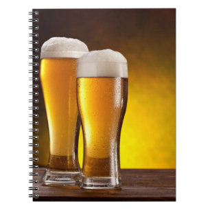 Caderno Espiral Dois copos de cervejas em uma mesa de madeira