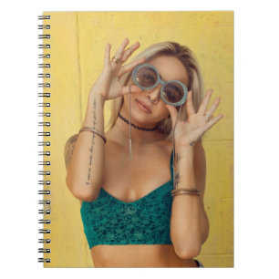 Caderno Espiral Mulher em bralette azul segurando óculos de sol c