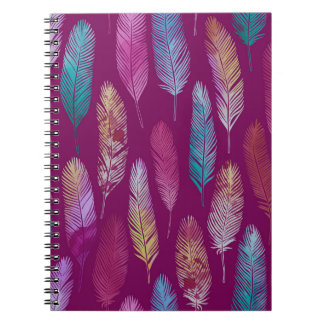 Caderno Espiral Penas coloridas: padrão de fundo roxo.