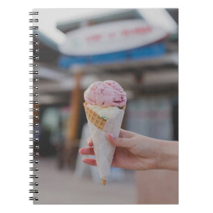 Caderno Espiral Pessoa que segura sorvete de morango