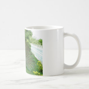 Café Peacock em uma caneca de fotos no jardim