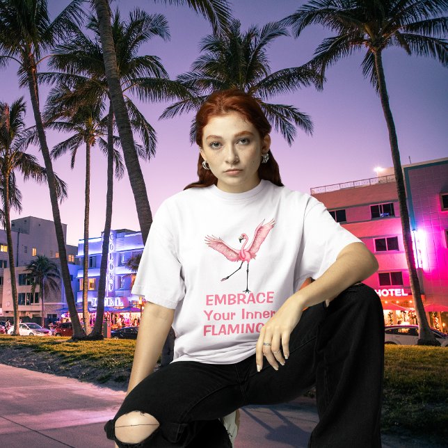 Camiseta Abra Seu Flamengo Interior Divertido (cool looking young woman wearing embrace your inner flamingo tee on neon lit Miami Florida streets)