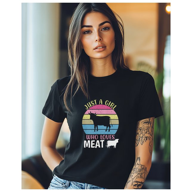 Camiseta Apenas Uma Menina Que Ama Dieta Carnívora De Carne (A woman wearing a black t-shirt with the image of a cow, and the words "Just a Girl who loves meat")