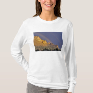 Camiseta Arco-íris duplo sobre uma formação rochosa perto d