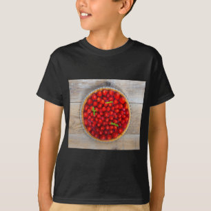 Camiseta Bagaço de morango com folhas de menta numa madeira