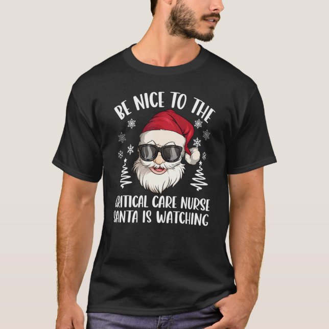 Camiseta Be Nice To The Critical Care Nurse Santa Is Watchi (Frente)