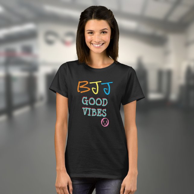Camiseta BJJ Estilo do Grafite Retroativo Good Vibes Black (Black BJJ Good Vibes T shirt worn by a female model in a gym)