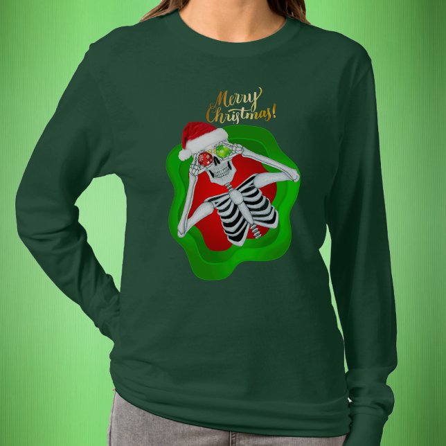 Camiseta Bobo de Natal Skeleton Santa Hat Spatter (Fun Skeleton in Santa Hat in splatter shape with Gold Merry Christmas text on green womans shirt.)