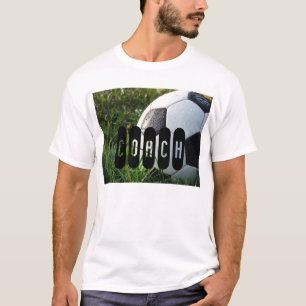 Camiseta Bola de futebol preto e branco no t-shirt da grama