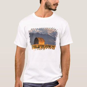 Camiseta Celeiro antigo enquadrado por fardos de feno e dra