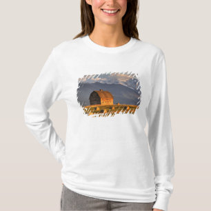 Camiseta Celeiro antigo enquadrado por fardos de feno e dra