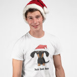 Camiseta Dachshund Santa Clause Encantador Engraçado Natal<br><div class="desc">Um filhote de cachorro preto e salsicha bronzeado e cabeludo vestindo um chapéu de Papai Noel. Esta engraçada camisa de Natal Dachshund está disponível em muitos estilos, incluindo t-shirts, camisas de manga longa e capuzes. Divertido, roupa do amante do cachorro para o próximo encontro de férias. Visite o Doodle World...</div>