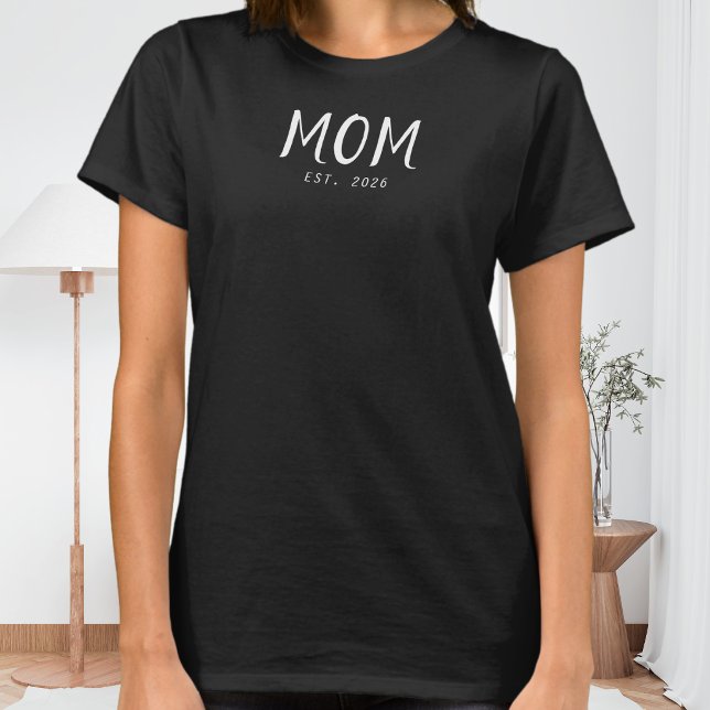 Camiseta de Presente para Mãe Recém-Constituída (A black t-shirt with white customizable text saying "Mom Est. 2026")