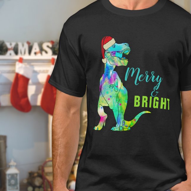 Camiseta Dinossauro de Natal Engraçado e feliz (Merry and bright funny Christmas dinosaur T-shirt Colorful T-Rex wearing a santa hat )