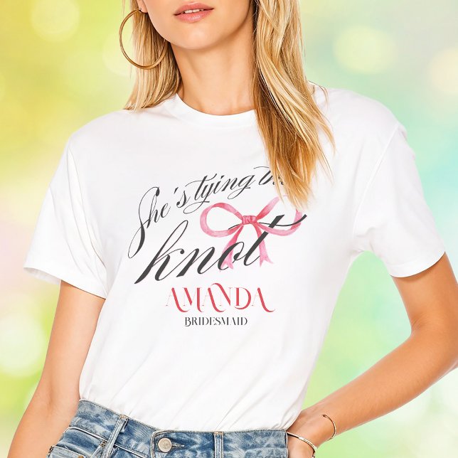 Camiseta Ela Está Amarrando o Nó Laço Coquete Solteira (She's Tying the Knot Pink Bow Coquette Elegant Typography Bachelorette Bridal Shower Squad T-Shirt)