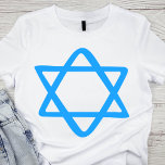 Camiseta Estrela Azul de David<br><div class="desc">Esta elegante camiseta branca apresenta uma estrela azul impressionante de David, simbolizando a herança e identidade judaicas. As linhas limpas e a cor azul vibrante fazem o design se destacar, criando um eterno e um pedaço significativo de roupa. Perfeito para eventos religiosos, comemorações culturais, ou veste cotidiano, esta camiseta permite...</div>