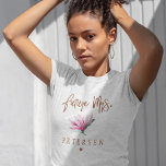 Camiseta Futuro noiva do time de tipografia floral da Sra.<br><div class="desc">Glam elegante futuro personalizado floral Sra. t-shirt com brilho de cobre escovado manuscrito, como um guião tipográfico, uma flor de magnólia de cor-d-água rosa e pincelada, e um pequeno coração. Fácil de personalizar com a noiva para ser um nome futuro. Adequado para a primavera ou a moda de verão moderna...</div>