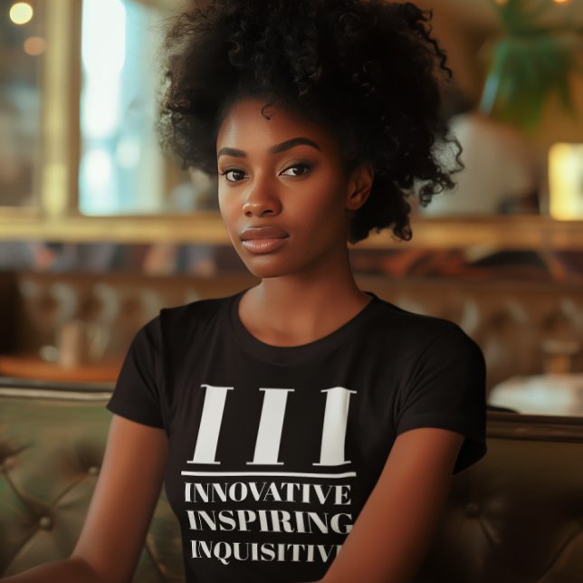 Camiseta III- Inovador, Inspirador, Inquisitivo (Young black woman wears a "III: Innovative, Inspiring, Inquisitive" black t-shirt.)