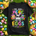 Camiseta I'm Just Here For The Eggs & The Chocolate<br><div class="desc">Let's be honest — the eggs and chocolate are the real reason we show up! This adorable and funny Easter t-shirt features a cute white bunny peeking up from the grass wearing cool sunglasses, nestled among colorful pastel Easter eggs, carrots, and spring flowers. The playful multicolor typography reads "I'm Just...</div>
