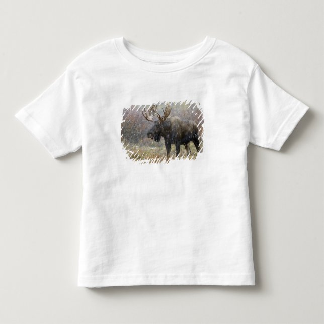 Camiseta Infantil Alce macho em tempestade de neve com árvores de ál (Frente)