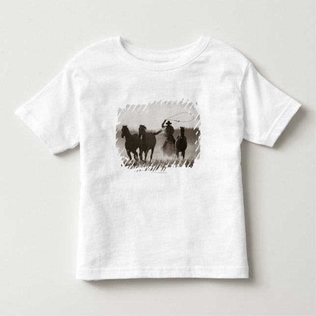 Camiseta Infantil Foto branca e negra de um cowboy abando de cavalos (Frente)