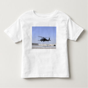 Camiseta Infantil HH-60G Pave Hawk decolando de Camp Bastio