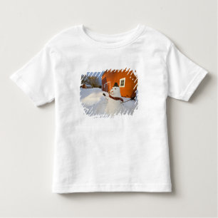 Camiseta Infantil Homem de neve em frente ao celeiro vermelho em Col