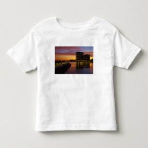 Camiseta Infantil Lagoa de recreação e apartamentos ao pôr do sol