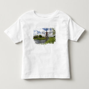 Camiseta Infantil Moinho de vento ao longo de um canal a leste de Le