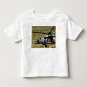 Camiseta Infantil Um HH-60 Pave Hawk voa sobre o deserto