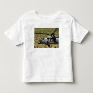 Camiseta Infantil Um HH-60 pavimenta o falcão voa sobre o deserto