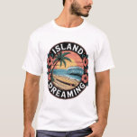 Camiseta Island Dreaming Tropical Art Vintage Surfboard<br><div class="desc">Immerse yourself in a coastal paradise with the "Island Dreaming" retro beach illustration. This high-impact graphic features a serene tropical landscape centered around a classic surfboard resting on a sandy shore, set against a perfectly curling turquoise wave. The scene is framed by a majestic, sun-drenched palm tree and a large,...</div>