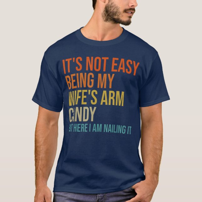 Camiseta Its Not Easy Being My Wifes Arm Candy But Here I A (Frente)