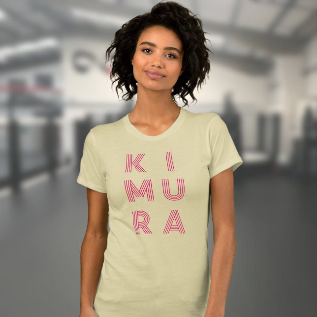 Camiseta Jiu Kimura Jiu Jitsu Cream, mulher do BJJ Kimura (Kimura BJJ t-shirt in cream worn by a female model in the gym.)