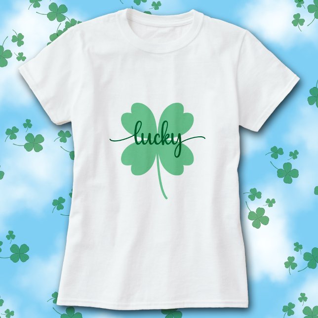 Camiseta Lucky Clover Script St. Patrick’s Day Tee        (White t-shirt with green Lucky script on a large solid green four-leaf clover graphic.)