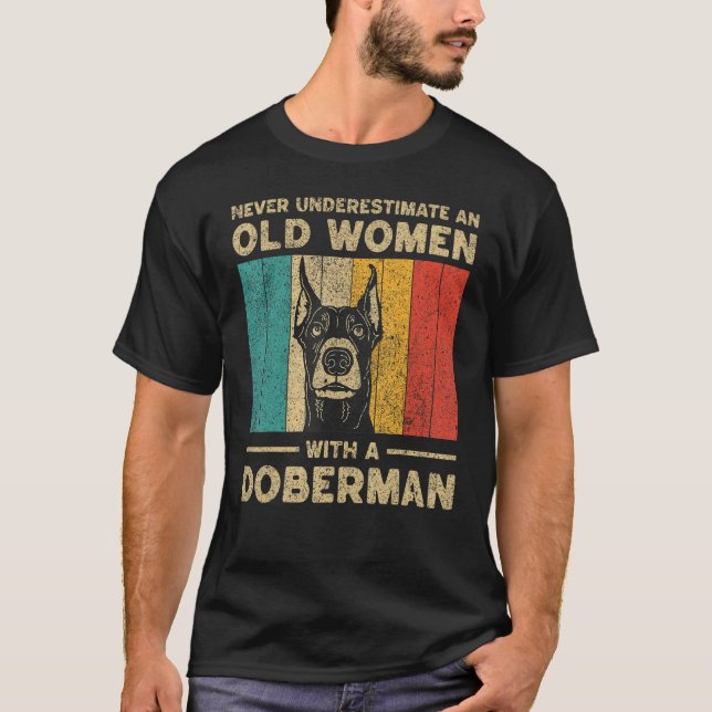 Camiseta Never Underestimate An Old Women With A Doberman P (Frente)