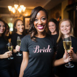Camiseta Noiva Rosa Claro Script Casamento Preto<br><div class="desc">Ela merece brilhar com essa camiseta preta elegante com "Noiva" em um script rosa claro. A tipografia de caligrafia refinada mantém o visual sofisticado e feminino, tornando-o versátil o suficiente para festas de despedida de solteira, chás de noiva, jantares de ensaio e momentos de preparativos. Uma maneira bonita e elegante...</div>