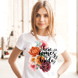 Camiseta O floral de aquarela aqui vem a noiva<br><div class="desc">Esta floral de aquarela aqui vem a camisa do estilo caligrafia da escrita da noiva é perfeita para a noiva ser.O design apresenta texto branco com flores em rosa,  vermelho,  laranja e marrom.</div>