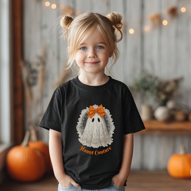 Camiseta Para Bebê Moda Assombrada em Renda Fantasma com Laço Laranja (Girl with blond pigtails wearing a black T-shirt with a ghost &"Haunt Couture".)
