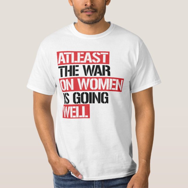 Camiseta Pelo menos a guerra contra as mulheres está indo b (Frente)
