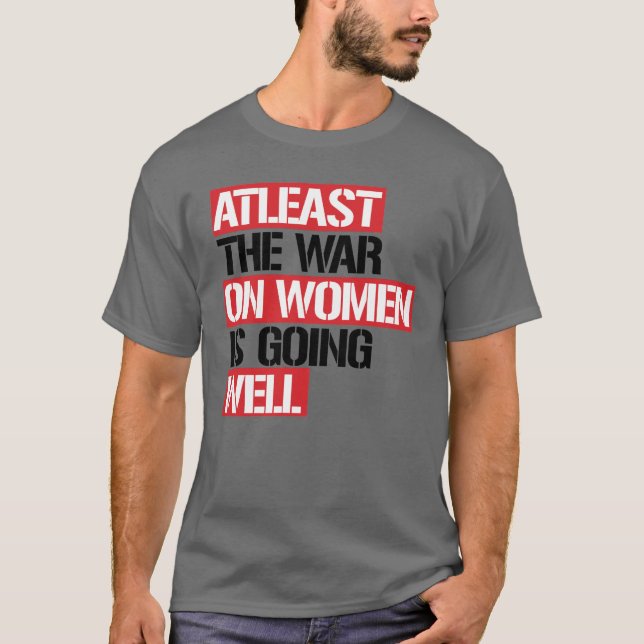 Camiseta Pelo menos a guerra contra as mulheres está indo b (Frente)
