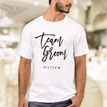 Camiseta Pincel Chic Tendência Preto Script Equipe Groom<br><div class="desc">Camiseta com as palavras "Team Groom" em elegante letra preta de pincel moderno,  perfeita para padrinhos e melhores amigos. Para outros itens correspondentes,  veja aqui https://www.zazzle.com/collections/119250194970828530?rf=238364477188679314</div>