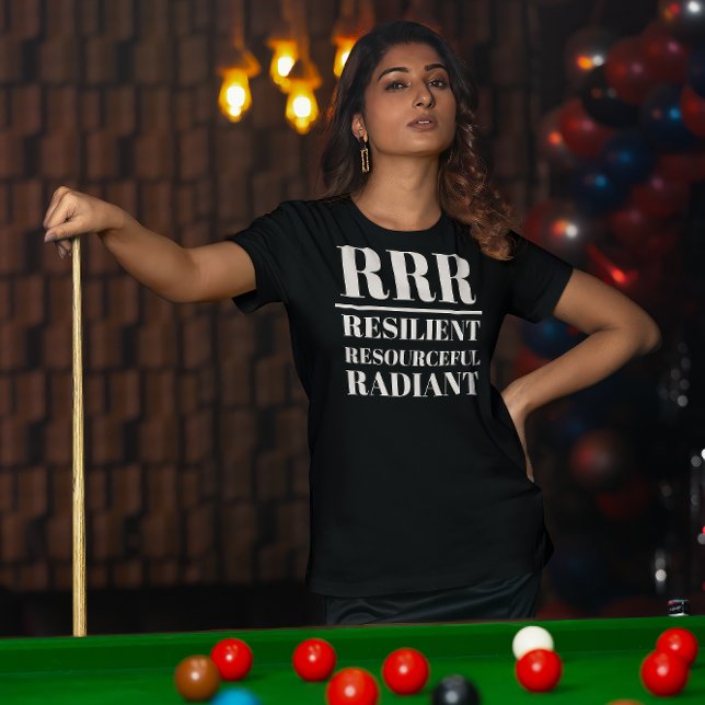 Camiseta RRR - Resiliente, Recursos, Radiante (Young woman wears a "RRR:Resilient, Resourceful, Radiant" black t-shirt.)