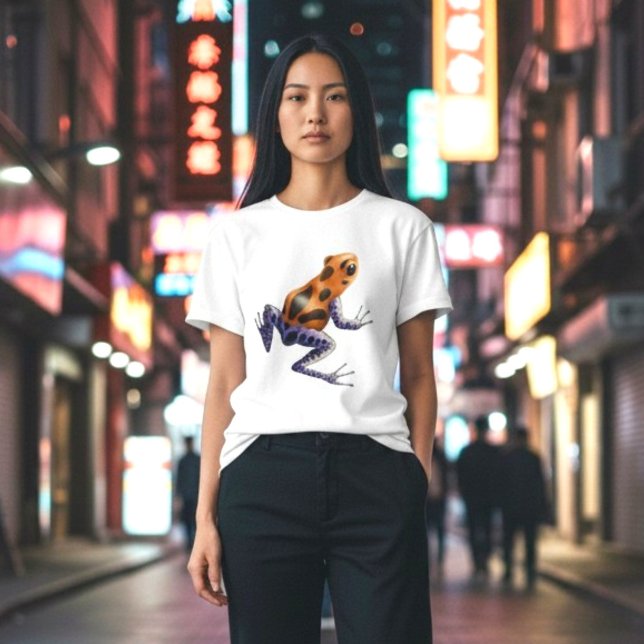 Camiseta Sapo Veneno (A vibrant orange and blue poison dart frog on a classic white tee, on a woman in the city at night.)