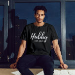 Camiseta Script branco Hubby "EST 202X" - Padrinhos de casa<br><div class="desc">Comemore o noivo com este na moda e personalize "Hubby Est. Camisa de despedida de solteiro de padrinhos de casamento de 202X". Esta camiseta preta apresenta um design moderno e elegante, fazer que seja uma obrigação para qualquer celebração pré-casamento. Criado com tecido confortável e de alta qualidade, é perfeito para...</div>