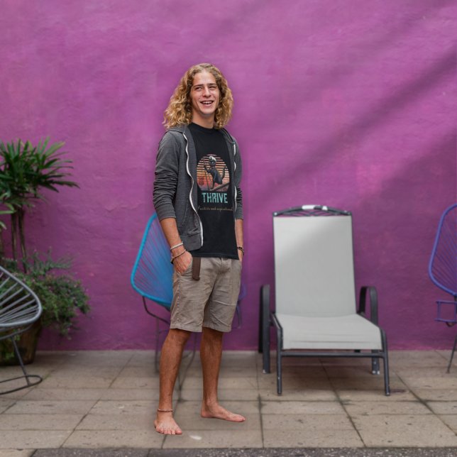 Camiseta Sunset de Gato Negro: Uma Viagem para prosperar (A man wears a Black Cat Sunset: A Voyage to THRIVE T-Shirt.)