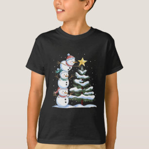 Camiseta Três bonecos de neve estão arranjando uma árvore d