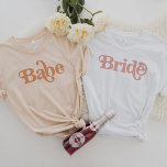 Camiseta Trixie Retro 70 Themed Groovy Babe Bachelorette<br><div class="desc">Esta camisa de solteira de bebês apresenta uma fonte temática retrô dos anos 70 em cor laranja cremosa. Ordene a opção da noiva branca para a futura noiva e as camisas laranja para o seu grupo de solteiros. As cores são editáveis! Clique em 'editar design' para criar suas próprias cores....</div>