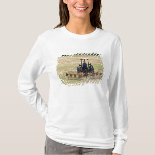 Camiseta Um jovem menino dirigindo um trator colhendo